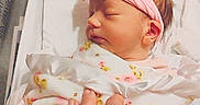Emily joined the competition — help win amazing prizes! newborn, baby, infant, sleeping, blanket, pink_headband, hand, tattoo, rings, hospital, crib, swaddled, cozy, resting, cute, portrait, skin, person, closeup, tender