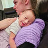 Emily is registered to the contest to win money with this photo: baby, young_adult, couch, blanket, smile, face, hand, clothing, portrait, indoor, relaxation, comfort, skin, hair, person, love, family, seated, happy, close_up