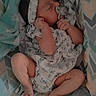 Emily is registered to the contest to win money with this photo: baby, infant, sleeping, pacifier, headband, floral_outfit, blanket, baby_nest, patterned, soft_toys, cute, newborn, resting, child, cozy, indoors, peaceful, small_hands, small_feet, closeup