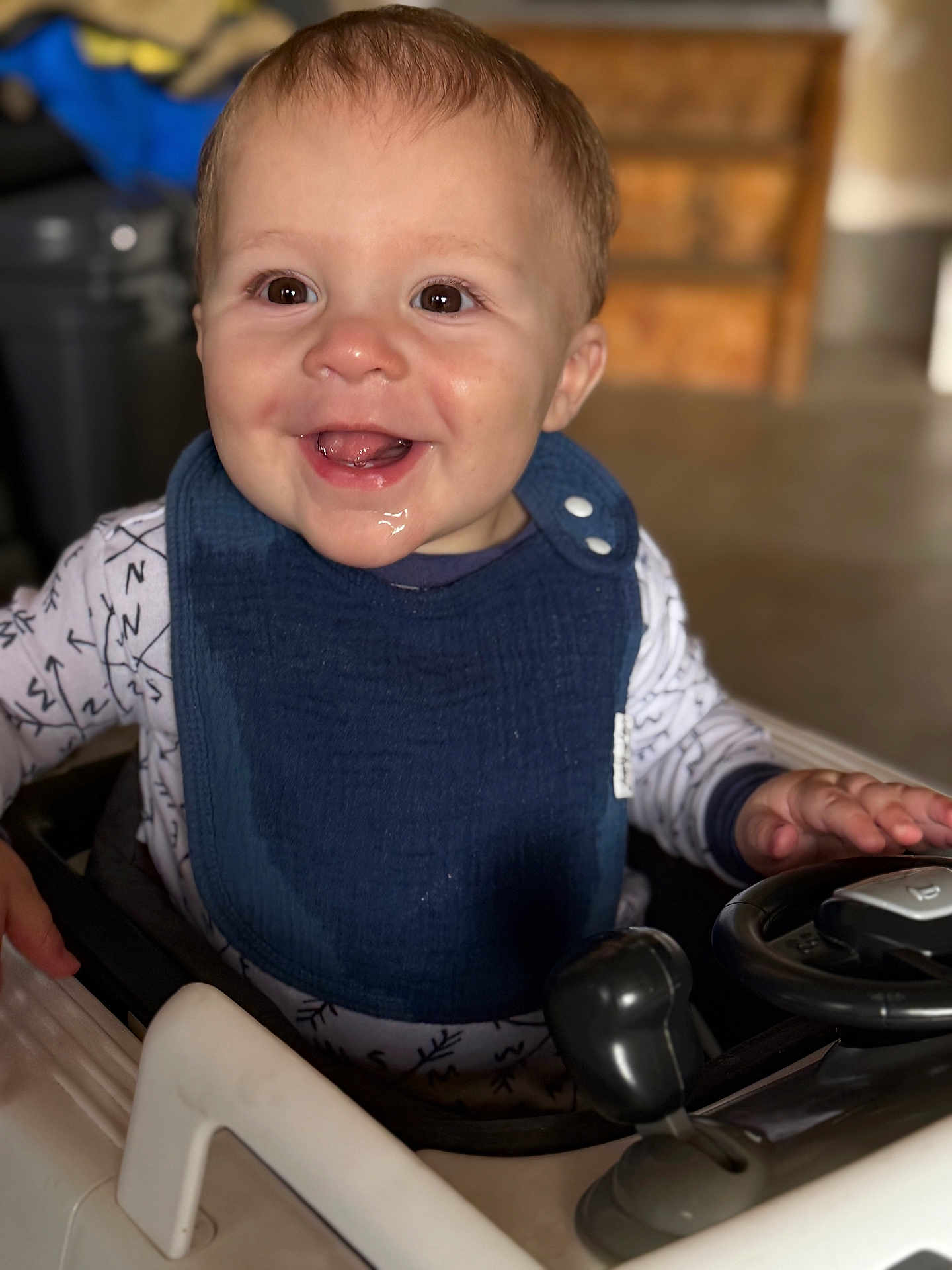 Caden joined the competition — help win amazing prizes! baby, child, smile, drool, bib, toy_car, steering_wheel, indoor, happy, face, hands, clothing, short_hair, infant, playtime, seat, cute, expression, portrait, closeup