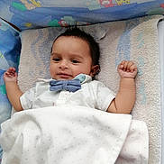 Melkior participe au concours pour gagner de l'argent avec cette photo : baby, infant, crib, blanket, bow_tie, shirt, face, arm, hand, sleeping_area, toddler, cute, child, indoors, comfort, resting, colorful, cartoon, animal_print, soft