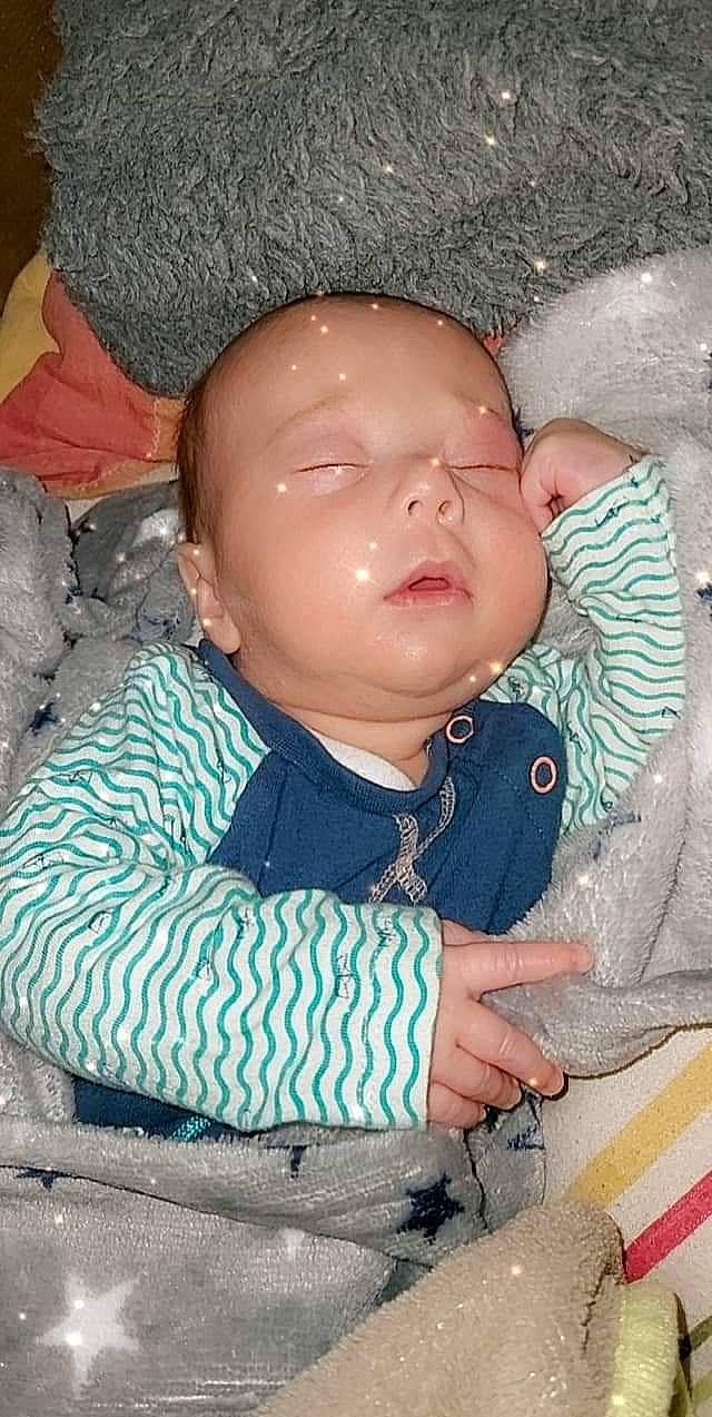 Aïezo participe au concours pour gagner de l'argent avec cette photo : baby, baby_products, baby_toddler_clothing, cheek, child, chin, comfort, eye, finger, forehead, lip, mouth, nose, person, pink, sitting, skin, sleeve, textile, toddler