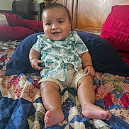 Leonitus joined the competition — help win amazing prizes! baby, child, smiling, shirt, shorts, bed, quilt, pillow, wooden_headboard, indoor, happy, sitting, infant, person, furniture, pattern, home, cute, toddler, skin