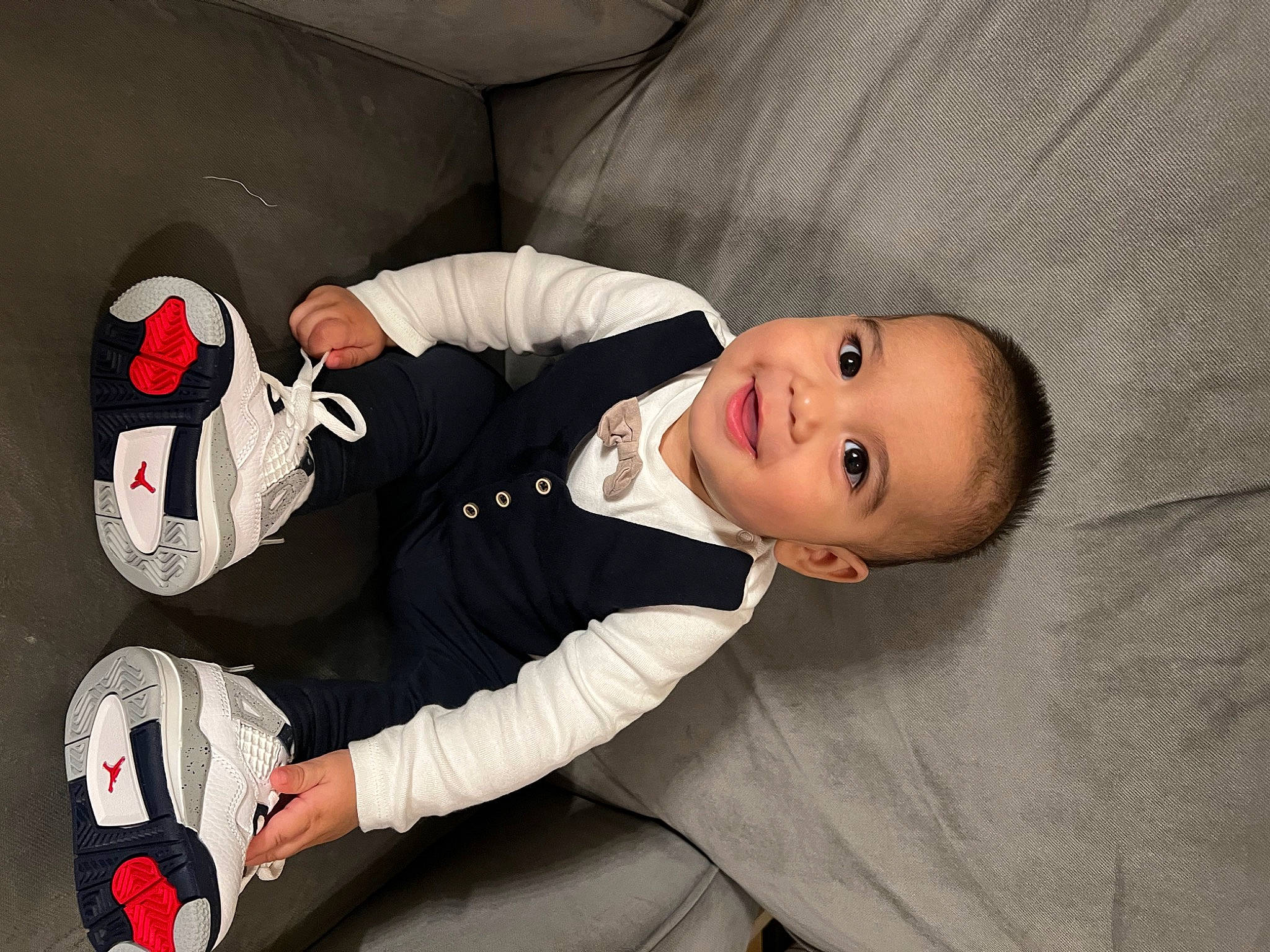 Boston is registered to the contest to win money with this photo: baby, baby_products, baby_toddler_clothing, carmine, child, comfort, flash_photography, flooring, fun, glove, joy, linens, mammal, mouth, person, personal_protective_equipment, room, sitting, sleeve, smile