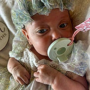 Lilah is registered to the contest to win money with this photo: baby, infant, pacifier, headband, lace, dress, hand, fist, face, skin, blanket, closeup, newborn, sleepwear, soft, cute, child, indoors, portrait, peaceful