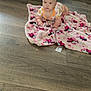 Journei joined the competition — help win amazing prizes! baby, infant, blanket, minnie_mouse, floor, wooden_floor, couch, living_room, child, cute, curious, indoors, person, clothing, pattern, pink, orange, face, hands, young