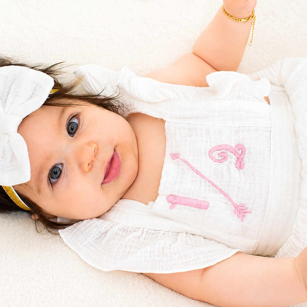 Liliana joined the competition — help win amazing prizes! baby, infant, girl, white_clothing, headband, bow, blue_eyes, bracelet, lying_down, soft_surface, portrait, cute, smiling, child, young, pink_embroidery, skin, fashion, adorable, closeup