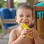 baby, background_blur, banana, child, cute, expression, food, fruit, furniture, hand, happy, indoor, natural_light, peeling, person, playful, skin, smile, toddler, young_child