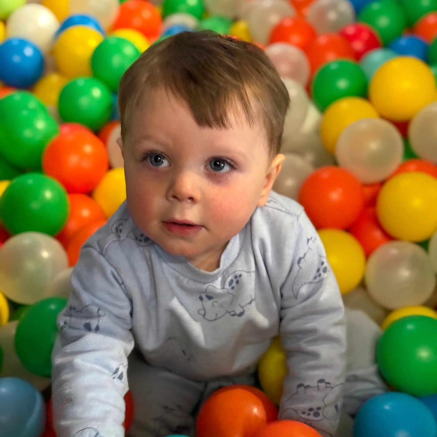 Ayden a rejoint le concours — aidez-le/la à gagner de superbes lots ! baby, ball_pit, blue_eyes, child, clothing, colorful, cute, expression, fun, happy, indoor, long_sleeve, plastic_balls, play, playtime, portrait, sitting, toddler, toy, young