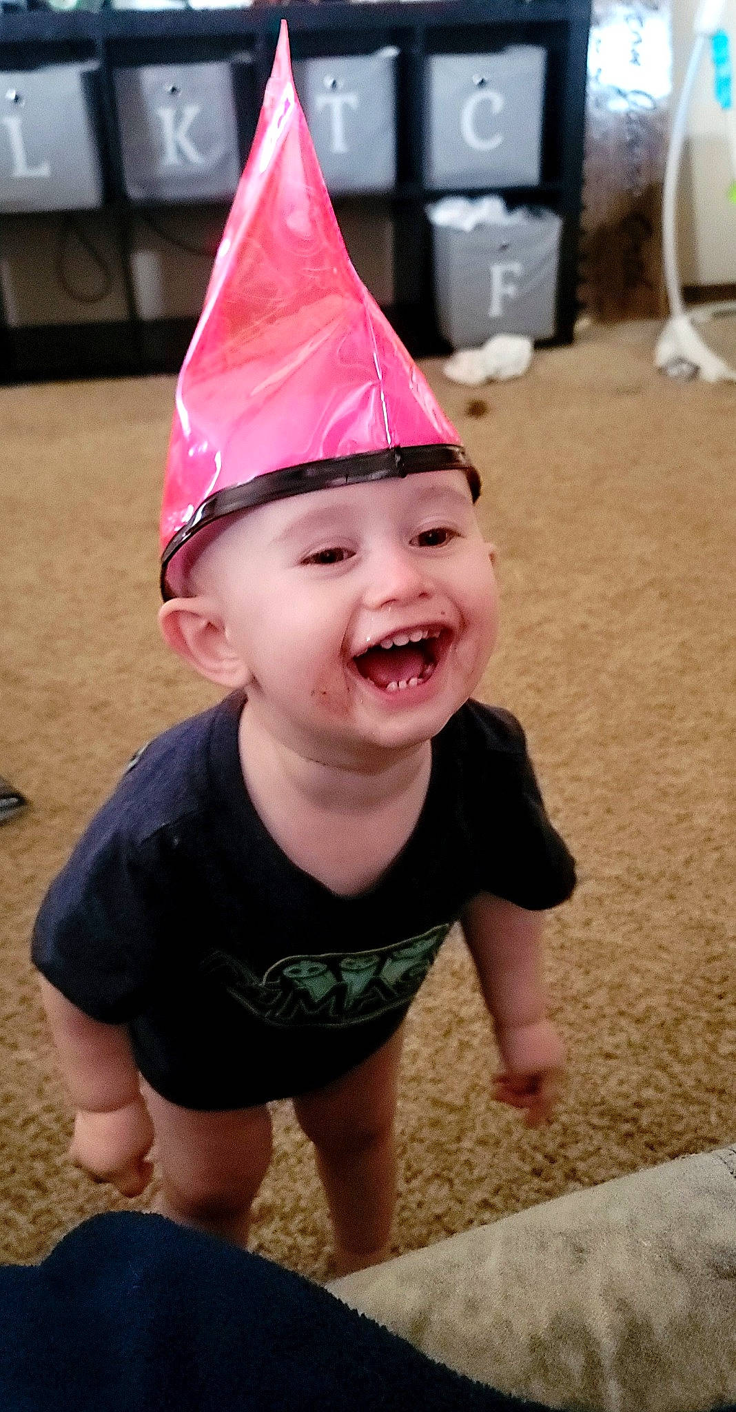 Camden is registered to the contest to win money with this photo: baby_toddler_clothing, cap, child, cone, costume_hat, eye, face, fashion_accessory, fun, grass, happy, headwear, leisure, magenta, party_hat, party_supply, person, pink, recreation, smile