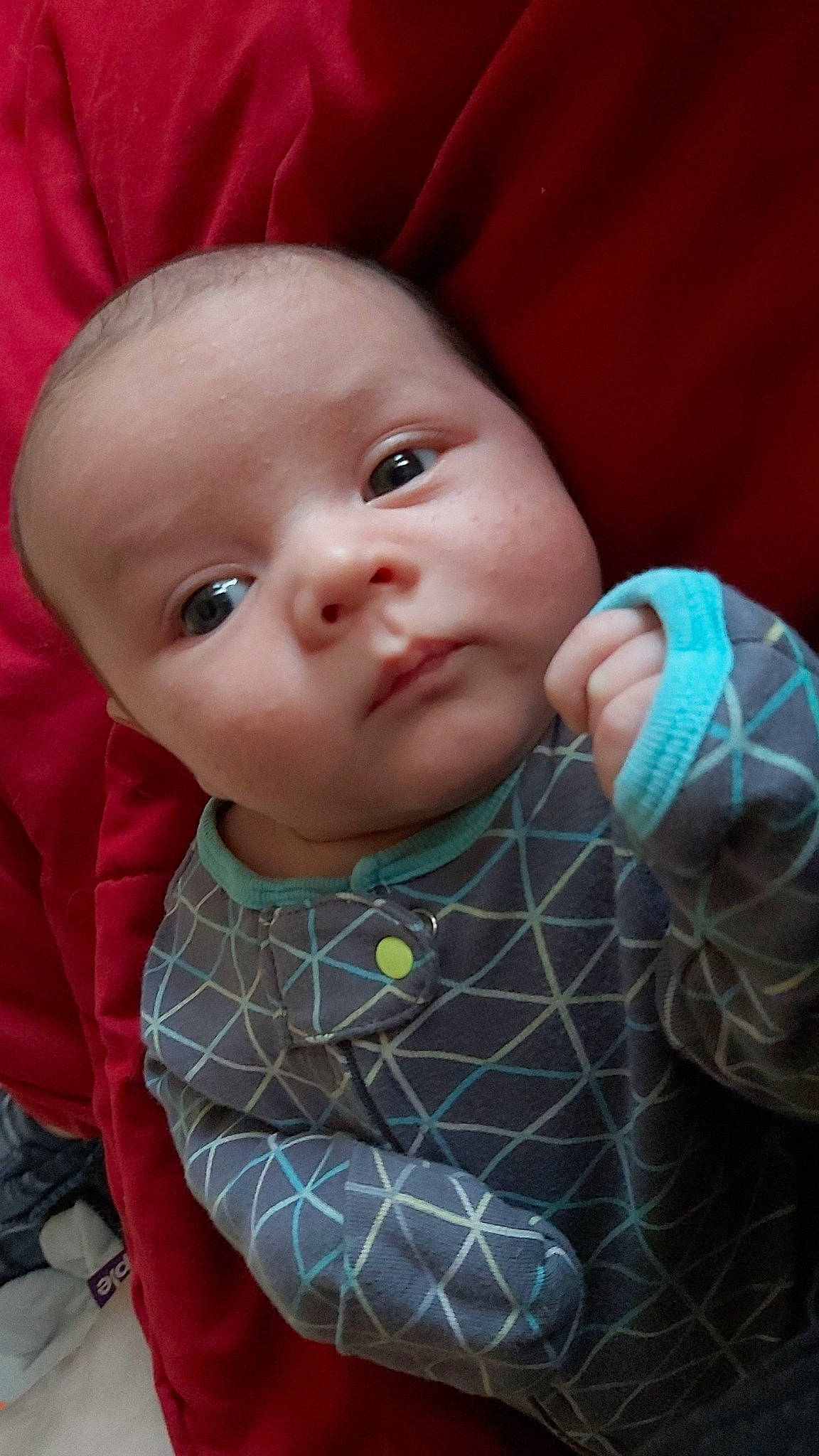 Henry is registered to the contest to win money with this photo: baby, baby_products, baby_toddler_clothing, cheek, child, comfort, iris, linens, lip, nose, outerwear, pattern, person, pink, plaid, product, sitting, skin, sleeve, textile