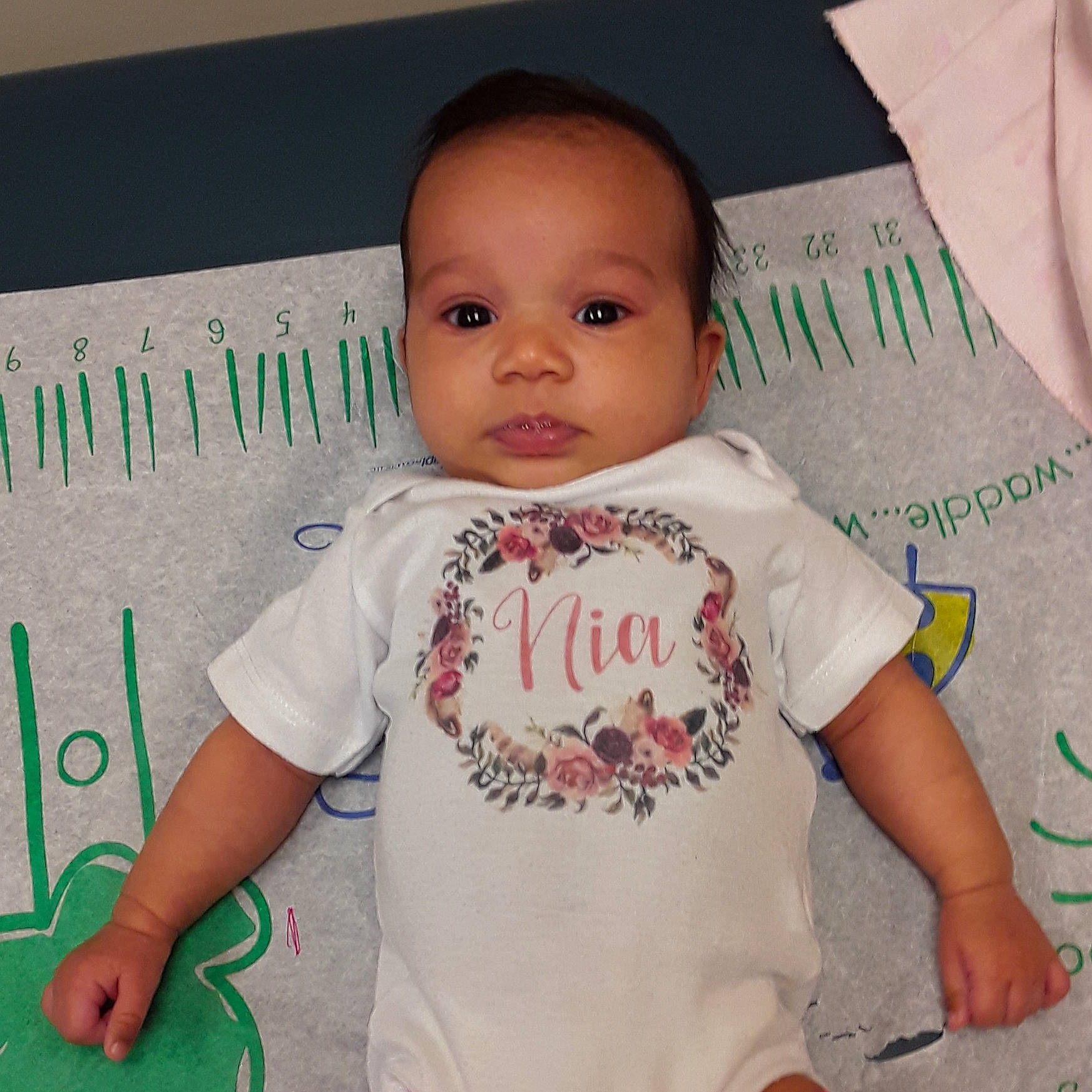 Nia is registered to the contest to win money with this photo: arm, baby, baby_products, baby_toddler_clothing, cheek, child, face, finger, head, lip, person, product, skin, sleeve, smile, t_shirt, toddler, top