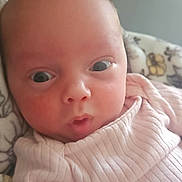 Susanna is registered to the contest to win money with this photo: baby, blanket, child, closeup, clothing, cute, expression, eyes, face, head, indoors, infant, newborn, person, pink, portrait, ribbed, skin, soft_light, young