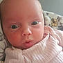 Susanna is registered to the contest to win money with this photo: baby, blanket, child, closeup, clothing, cute, expression, eyes, face, head, indoors, infant, newborn, person, pink, portrait, ribbed, skin, soft_light, young