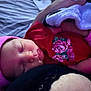 Lyrica is registered to the contest to win money with this photo: baby, sleeping, pink_hat, red_clothing, floral_pattern, blanket, soft_toy, close_up, infant, peaceful, cute, resting, bed, child, portrait, face, headwear, indoors, cozy, newborn