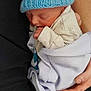 architecture, baby, beanie, blanket, bonnet, building, cap, clothing, couch, face, furniture, glove, hat, head, hospital, newborn, person, photography, portrait, sleeping