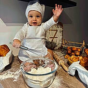 Hayden a rejoint le concours — aidez-le/la à gagner de superbes lots ! baby, child, chef_hat, whisk, flour, baking, kitchen, croissants, eggs, rolling_pin, basket, apron, smiling, messy, countertop, food, cute, cooking, portrait, happy