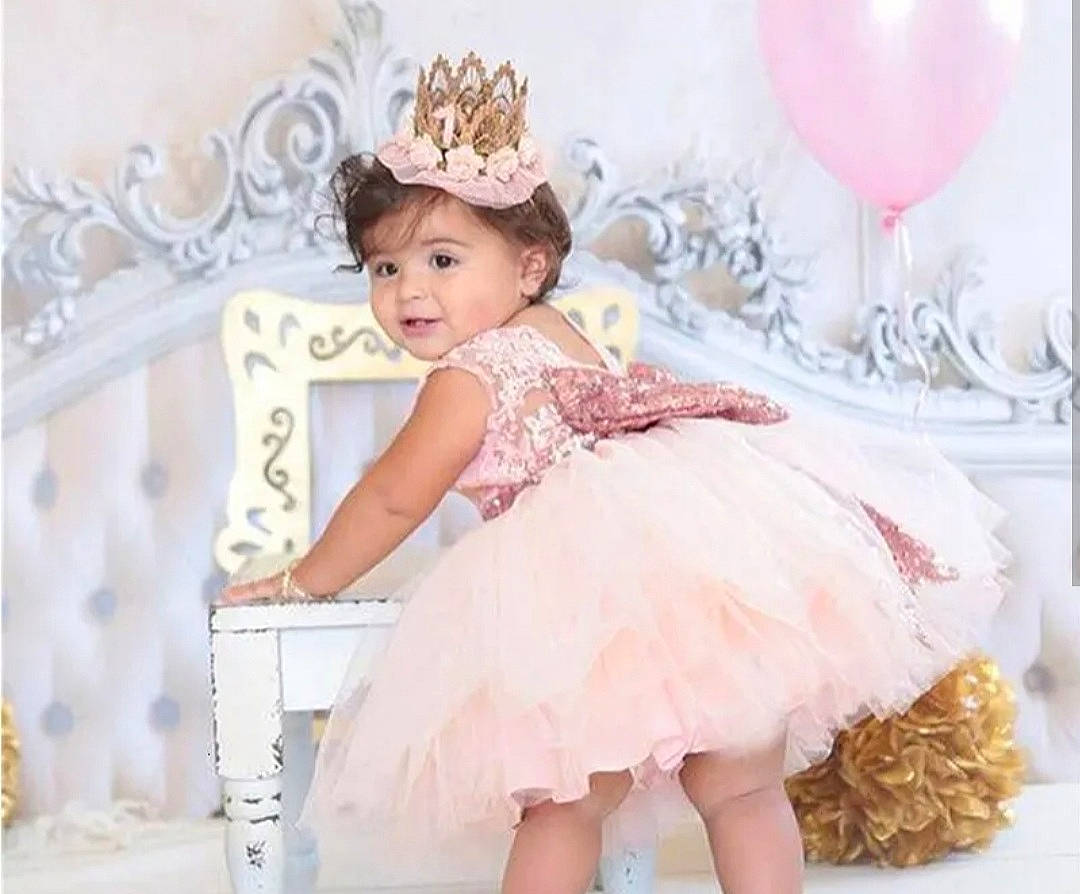 Lea a rejoint le concours — aidez-le/la à gagner de superbes lots ! baby_toddler_clothing, balloon, bridal_accessory, child, day_dress, dress, embellishment, event, fashion_design, happy, headgear, headpiece, peach, person, pink, purple, smile, textile, toddler, wedding_ceremony_supply