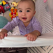Harley joined the competition — help win amazing prizes! baby, child, crib, toy, purple_clothing, bracelet, face, hands, indoor, carpet, bag, playpen, curious, infant, person, smiling, bright_eyes, home, cute, young