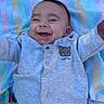 baby, infant, smiling, happy, lying_down, blanket, striped, clothing, shirt, pants, cute, child, outstretched_arms, indoor, portrait, face, head, casual, playful, young