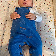Lyam participe au concours pour gagner de l'argent avec cette photo : baby, infant, blue_overalls, garfield, polka_dot, mattress, sign, clothing, socks, bedroom, cute, child, portrait, lying_down, hands, expression, indoor, young, person, resting