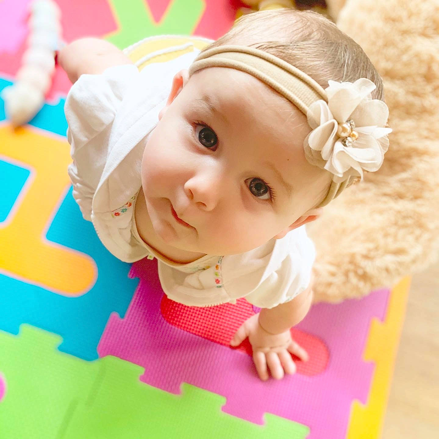 Vivianna is registered to the contest to win money with this photo: baby, baby_laughing, baby_toddler_clothing, cheek, child, ear, fashion_accessory, hair_accessory, headgear, headwear, pattern, person, pink, play, skin, toddler, tummy_time
