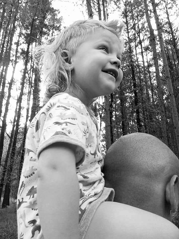 Everette is registered to the contest to win money with this photo: arm, black, black_and_white, cool, facial_expression, gesture, grass, hair, hairstyle, happy, human_body, people_in_nature, person, plant, sky, smile, standing, style, summer, toddler