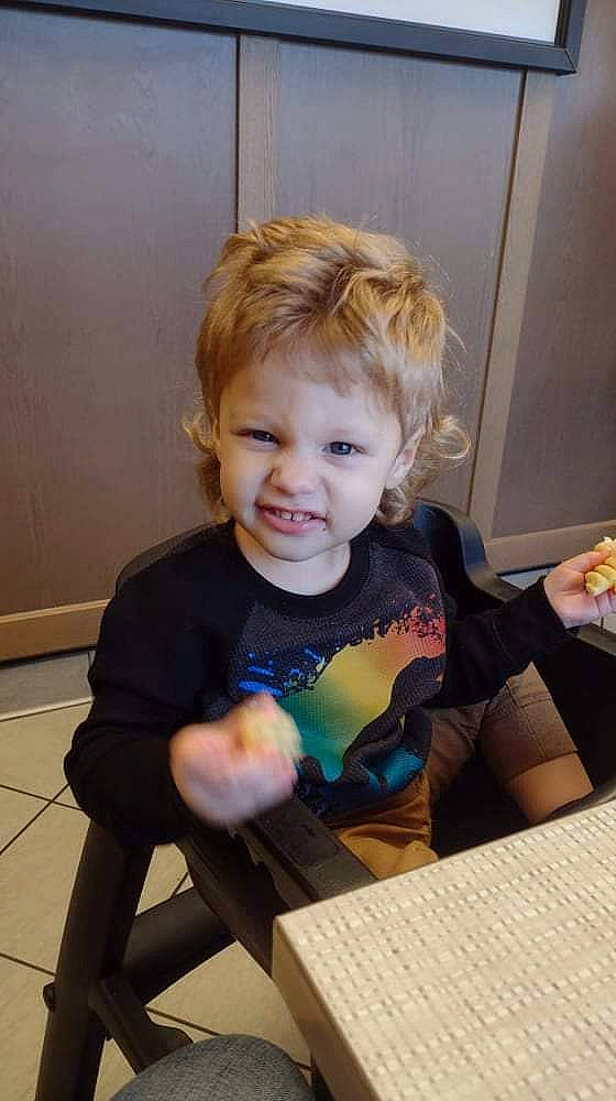 Everette is registered to the contest to win money with this photo: arm, baby, baby_toddler_clothing, cheek, child, flooring, fun, hair, happy, iris, person, play, room, sitting, sleeve, smile, standing, t_shirt, table, toddler