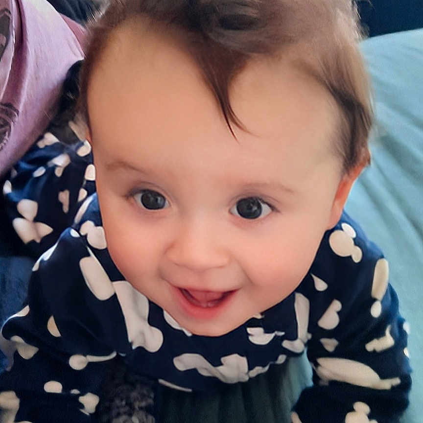 Maximus is registered to the contest to win money with this photo: baby, bed, bedroom, bodypart, clothing, couch, dress, face, finger, furniture, hand, happy, head, indoors, pants, person, photography, portrait, room, smile