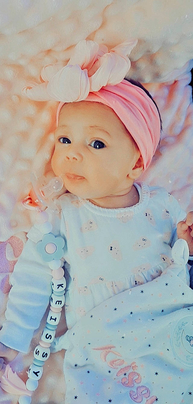 Keïssy a rejoint le concours — aidez-le/la à gagner de superbes lots ! baby, baby_toddler_clothing, cap, cheek, child, dress, fashion_accessory, grass, happy, headband, headgear, headwear, lip, pattern, person, pink, product, skin, sleeve, textile