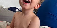 Thymaël a rejoint le concours — aidez-le/la à gagner de superbes lots ! toddler, child, laughing, smiling, shirtless, blanket, indoor, person, happy, face, arm, skin, hair, adult, couch, furniture, casual, relaxed, family, home