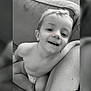 child, smiling, diaper, couch, arm, black_and_white, happy, indoor, portrait, baby, sitting, face, head, person, young, skin, hair, expression, closeup, candid