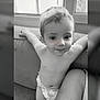 toddler, child, diaper, smile, couch, indoor, window, black_and_white, happy, arms_outstretched, young_child, person, face, hair, skin, infant, baby, cute, portrait, seated