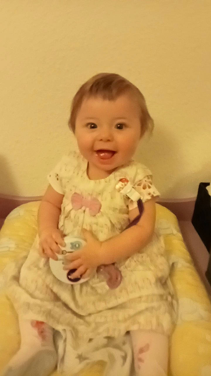 Isabella a rejoint le concours — aidez-le/la à gagner de superbes lots ! arm, baby, baby_toddler_clothing, cheek, child, day_dress, dress, embellishment, fun, happy, head, iris, one_piece_garment, person, sitting, skin, sleeve, smile, standing, toddler