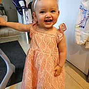 Elyne a rejoint le concours — aidez-le/la à gagner de superbes lots ! toddler, child, smiling, dress, indoor, headband, pink, happy, person, floor, furniture, hand, face, cute, clothing, pattern, standing, baby, young_child, room
