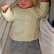 Elio participe au concours pour gagner de l'argent avec cette photo : baby, newborn, infant, sleeping, knit_hat, cardigan, blanket, bassinet, stroller, cozy, soft_fabric, gray_pants, footed_pants, closed_eyes, peaceful, tiny_hands, portrait, indoor, nap, swaddle