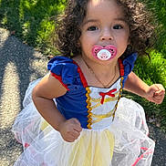 Maria Helena joined the competition — help win amazing prizes! toddler, child, pacifier, curly_hair, princess_dress, costume, outdoor, daylight, grass, sidewalk, blue_dress, white_tulle, red_trim, gold_detail, necklace, portrait, cute, young_child, person, smile