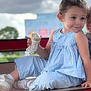 Jennah a rejoint le concours — aidez-le/la à gagner de superbes lots ! child, ice_cream, blue_clothing, sitting, table, smile, playful, outdoor, cloudy_sky, white_shoes, casual, person, happy, young_child, fun, summer, snack, cute, daylight, portrait