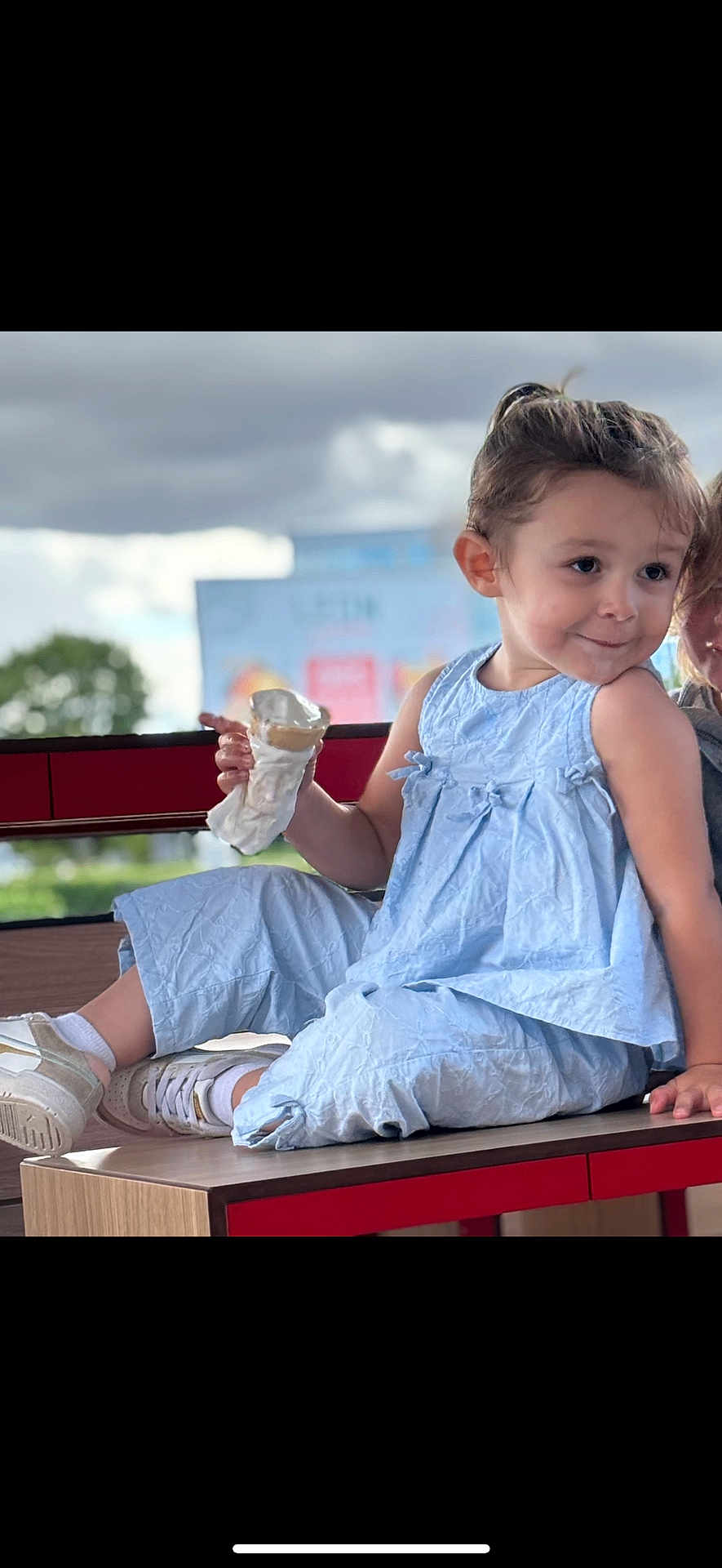 Jennah a rejoint le concours — aidez-le/la à gagner de superbes lots ! child, ice_cream, blue_clothing, sitting, table, smile, playful, outdoor, cloudy_sky, white_shoes, casual, person, happy, young_child, fun, summer, snack, cute, daylight, portrait