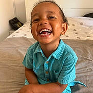 Adam participe au concours pour gagner de l'argent avec cette photo : toddler, child, smiling, happy, indoor, bed, bedroom, clothing, turquoise, person, sitting, crossed_legs, cute, young_child, portrait, skin, face, hair, button_up_shirt, casual
