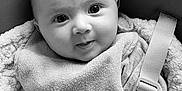 Méora participe au concours pour gagner de l'argent avec cette photo : baby, infant, face, eyes, smile, bib, car_seat, harness, buckle, blanket, hand, clothing, portrait, monochrome, black_and_white, head, cheeks, strap, cozy, closeup