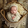 Méora participe au concours pour gagner de l'argent avec cette photo : baby, basket, closed_eyes, cozy, doily, fur_blanket, hands, infant, knitted_hat, newborn, newborn_photography, peaceful, portrait, prop_photography, sleeping, soft_texture, stuffed_animal, swaddle, toy, wooden_floor