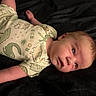 Jack joined the competition — help win amazing prizes! baby, infant, onesie, dinosaur_print, clothing, lying_down, blanket, face, head, skin, arm, newborn, portrait, cute, child, indoor, expression, human, young, resting
