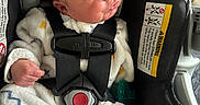 Jack joined the competition — help win amazing prizes! newborn, baby, car_seat, infant, sleeping, onesie, clothing, safety_harness, red_button, cushion, strap, child, face, hand, cozy, patterned, indoors, cute, resting, transportation