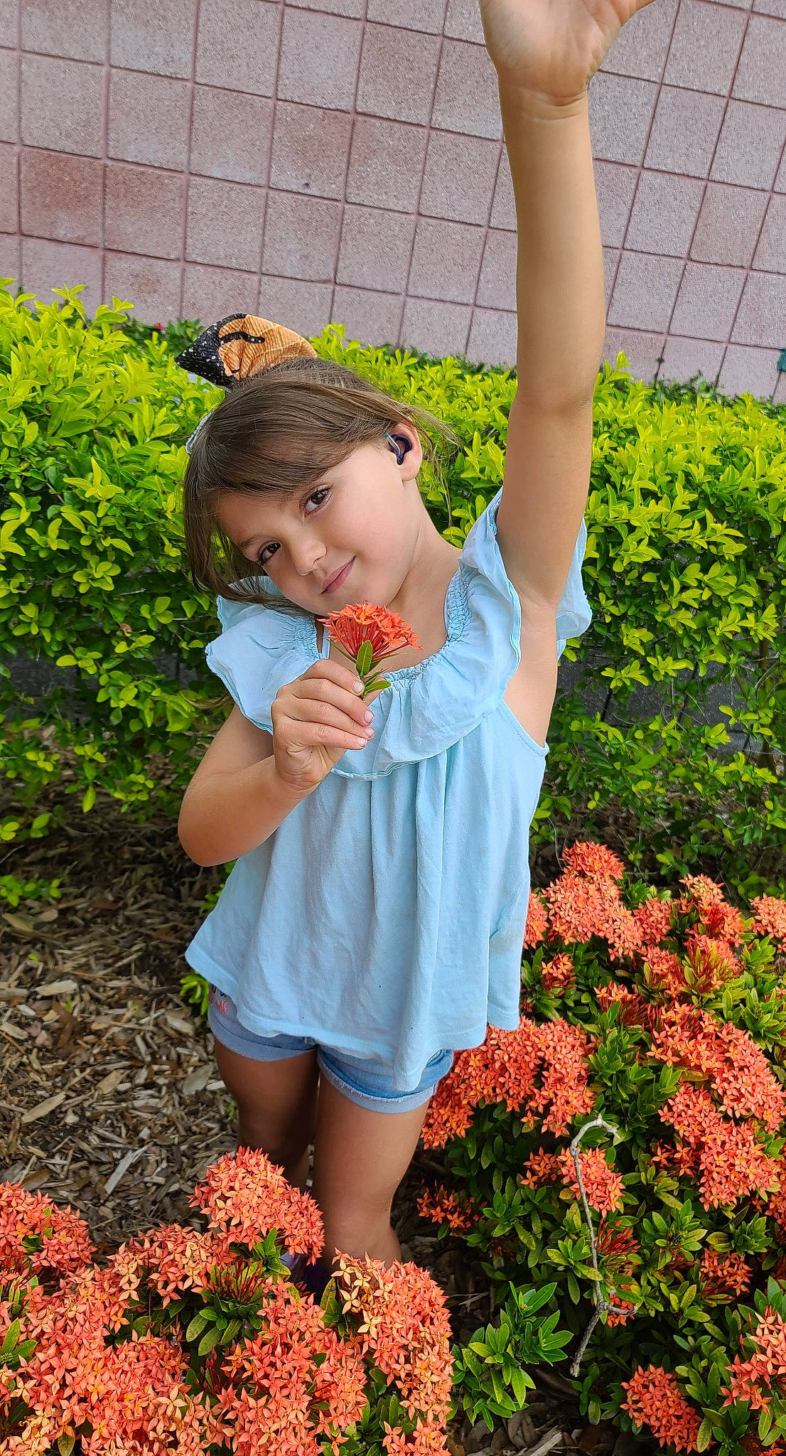 Skye is registered to the contest to win money with this photo: botany, flower, gesture, grass, grass_family, green, groundcover, happy, joint, joy, leaf, nature, orange, people_in_nature, person, petal, pink, plant, red, summer