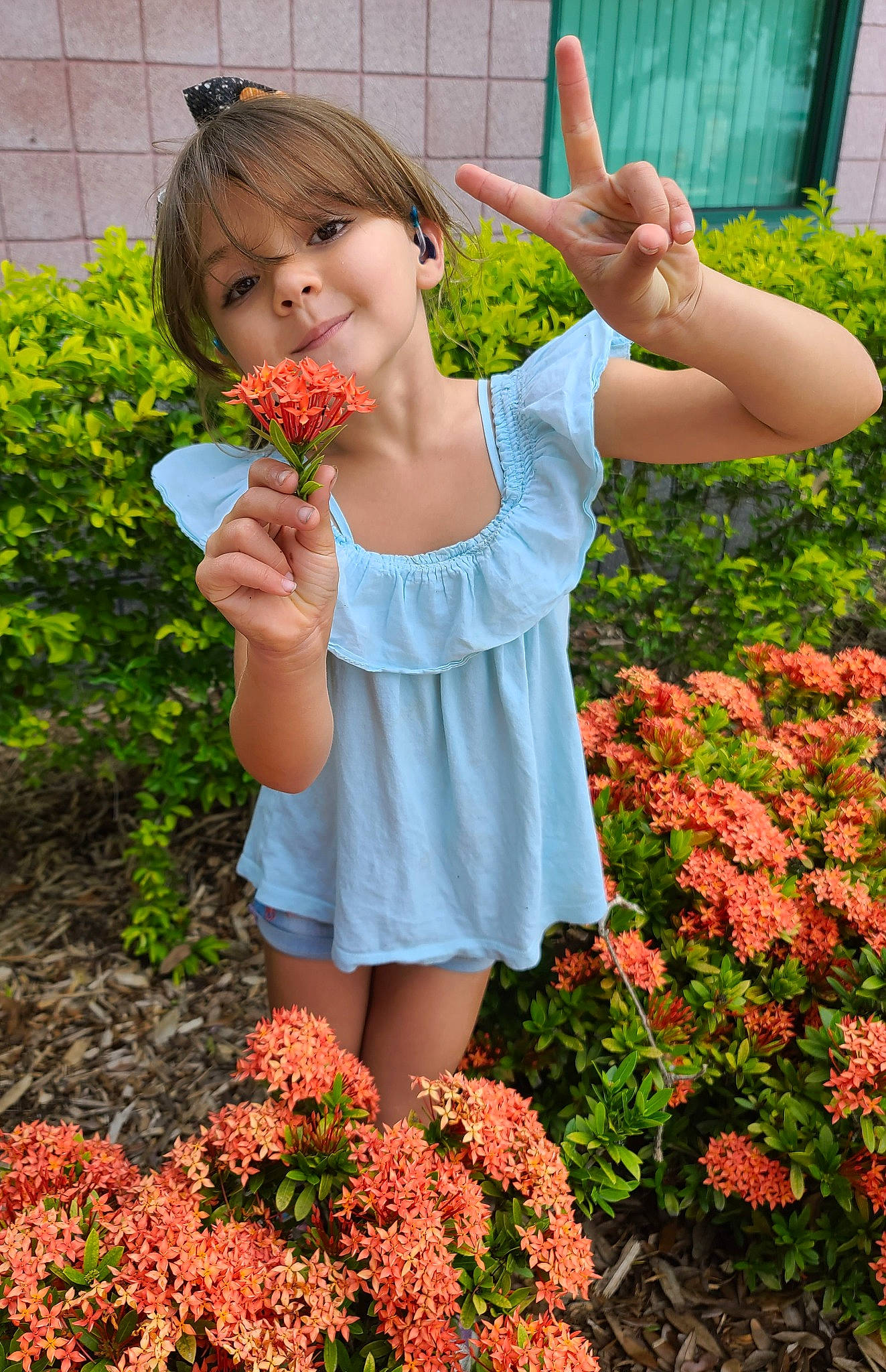 Skye is registered to the contest to win money with this photo: annual_plant, beauty, botany, flower, flowering_plant, gesture, grass, green, groundcover, happy, orange, people_in_nature, person, petal, pink, plant, red, shrub, smile, summer