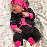 Layla is registered to the contest to win money with this photo: baby, black_clothing, blanket, child, cute, face, giraffe_pattern, hand, headband, indoors, infant, lying_down, newborn, pink_clothing, portrait, sleeping, smiling, socks, soft_texture, sporty