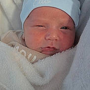 élio participe au concours pour gagner de l'argent avec cette photo : newborn, baby, hat, blue_hat, blanket, sleepy, face, cozy, soft_texture, wrapped, infant, cute, child, young, warm, snug, expression, resting, indoors, portrait