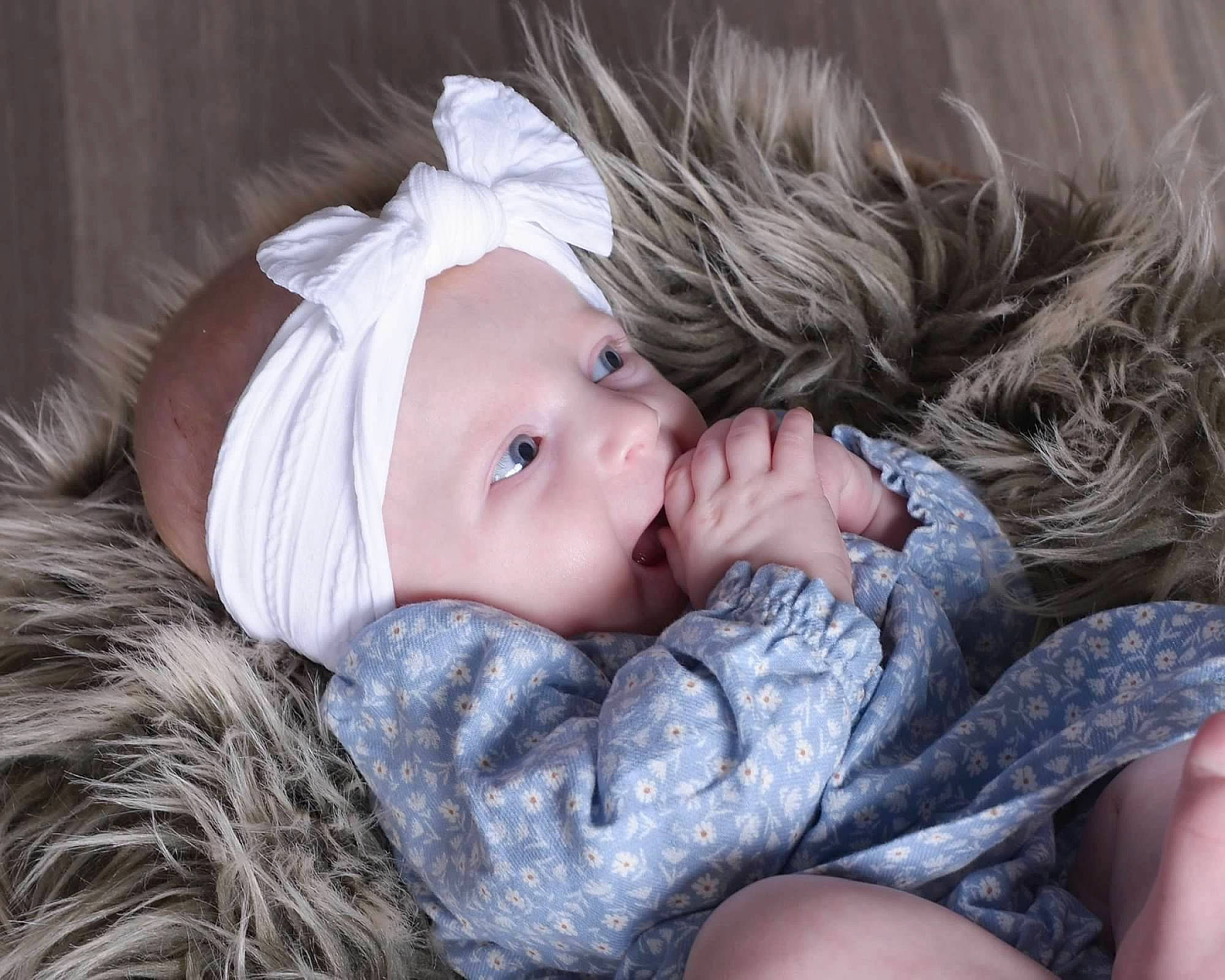Gia is registered to the contest to win money with this photo: baby, baby_toddler_clothing, brown_hair, cheek, child, comfort, eye, eyebrow, eyelash, fashion_accessory, flash_photography, fur, grass, happy, headwear, iris, lip, person, portrait_photography, sitting