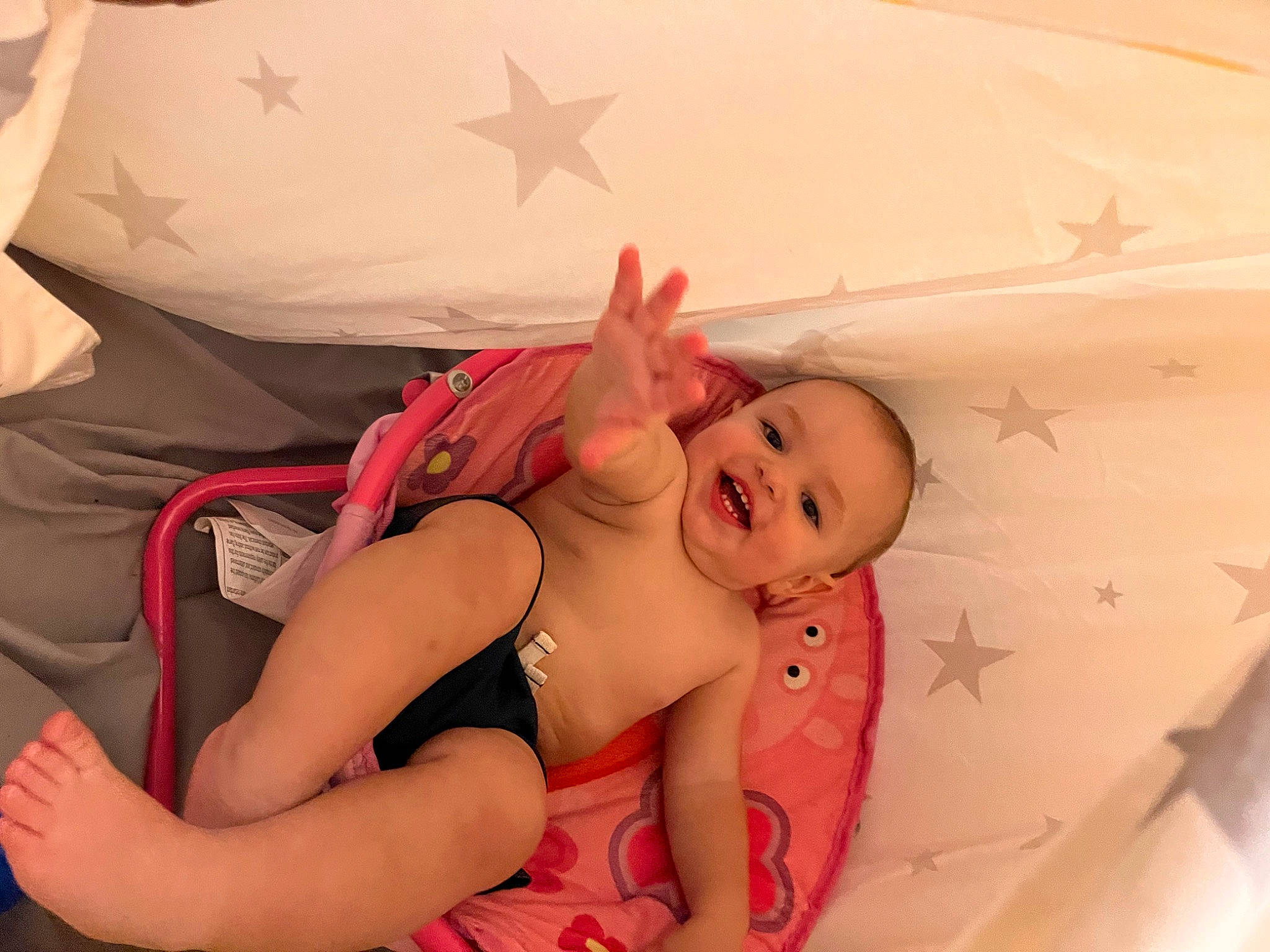 Levi is registered to the contest to win money with this photo: arm, baby, baby_toddler_clothing, cheek, chest, comfort, finger, gesture, hand, happy, headgear, human_body, mouth, muscle, person, pink, skin, smile, stomach, textile